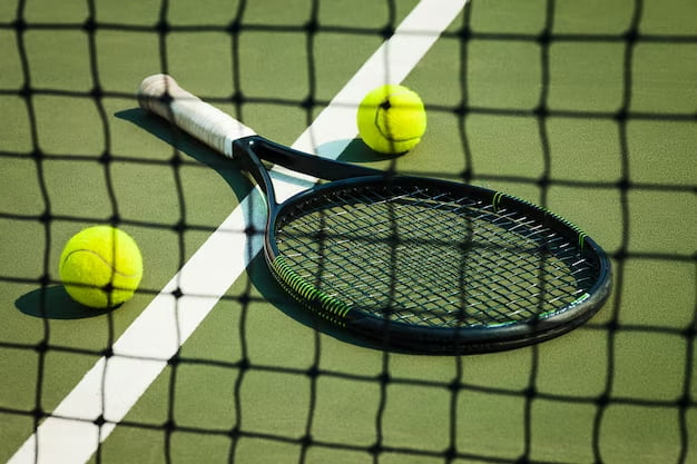 A tennis racket lies next to two balls